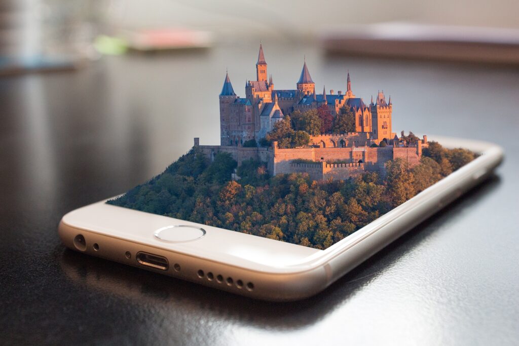 Celular sobre a mesa com um castelo medieval 3D saindo da tela. Trazendo a ideia de que Dicas de Segurança Digital criam uma fortaleza em seu dispositivo.